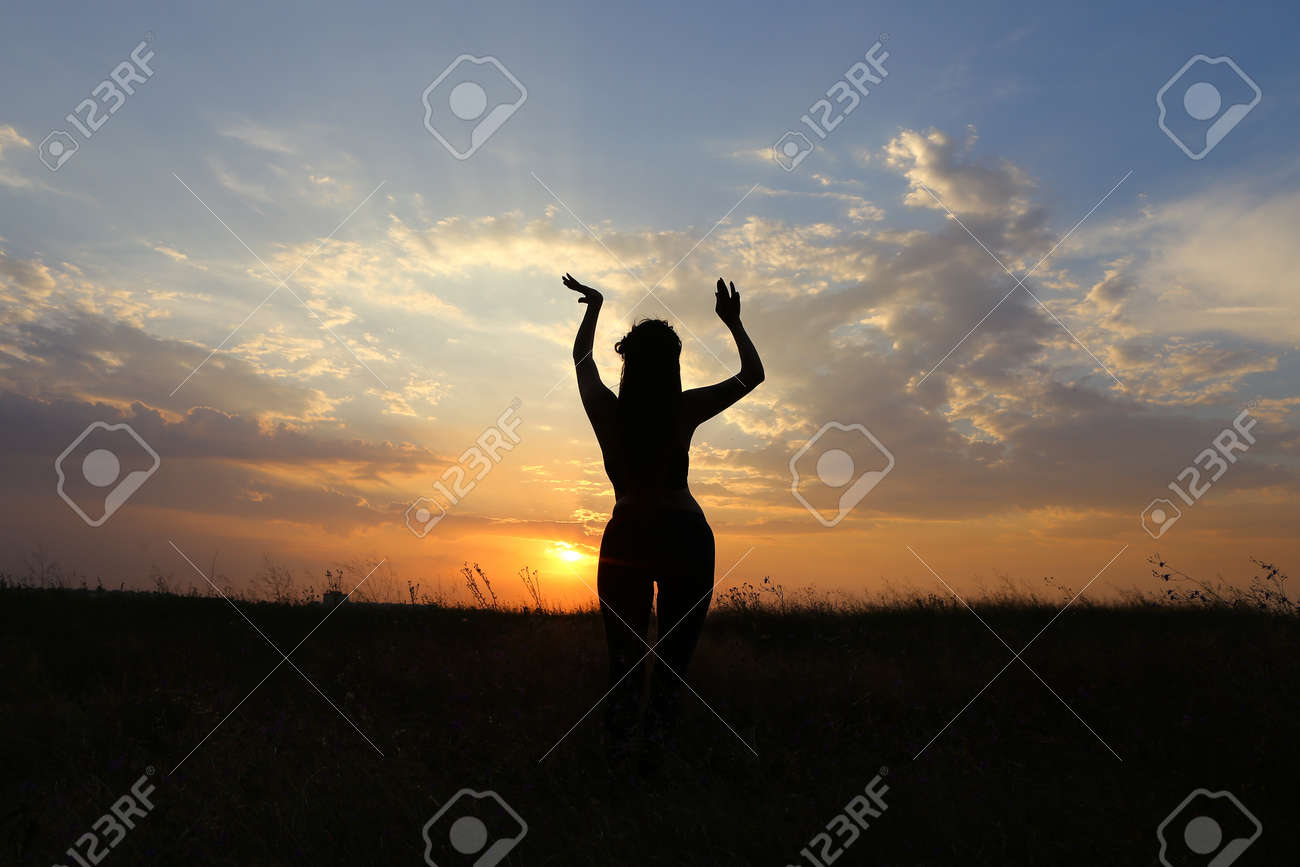 美しい姿の女性は ヨガのポーズ 体操とバレエ ストレッチや瞑想 広告撮影フィットネス スタジオ サンセット イエローとおしゃれの背景上に広いフィールドの中でベリーダンスを踊り健康エナジード リンクのためにポーズを費やしています の写真素材 画像素材 Image