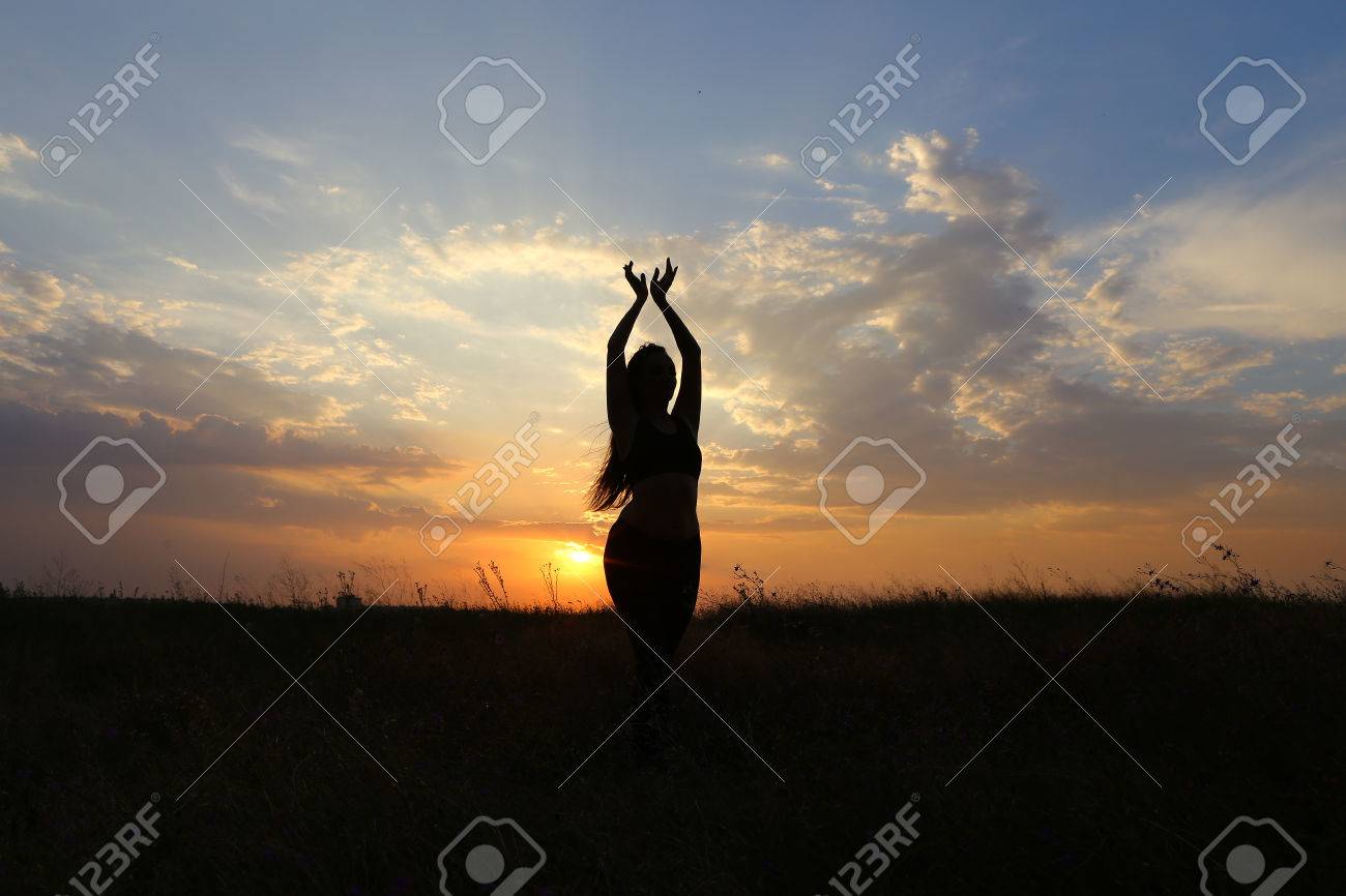 美しい姿の女性は ヨガのポーズ 体操とバレエ ストレッチや瞑想 広告撮影フィットネス スタジオ サンセット イエローとおしゃれの背景上に広いフィールドの中でベリーダンスを踊り健康エナジード リンクのためにポーズを費やしています の写真素材 画像素材 Image
