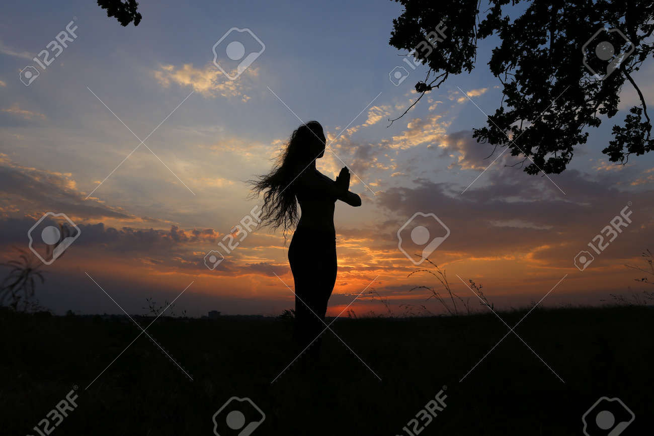 美しい姿の女性は ヨガのポーズ 体操とバレエ ストレッチや瞑想 広告撮影フィットネス スタジオ サンセット イエローとおしゃれの背景上に広いフィールドの中でベリーダンスを踊り健康エナジード リンクのためにポーズを費やしています の写真素材 画像素材 Image