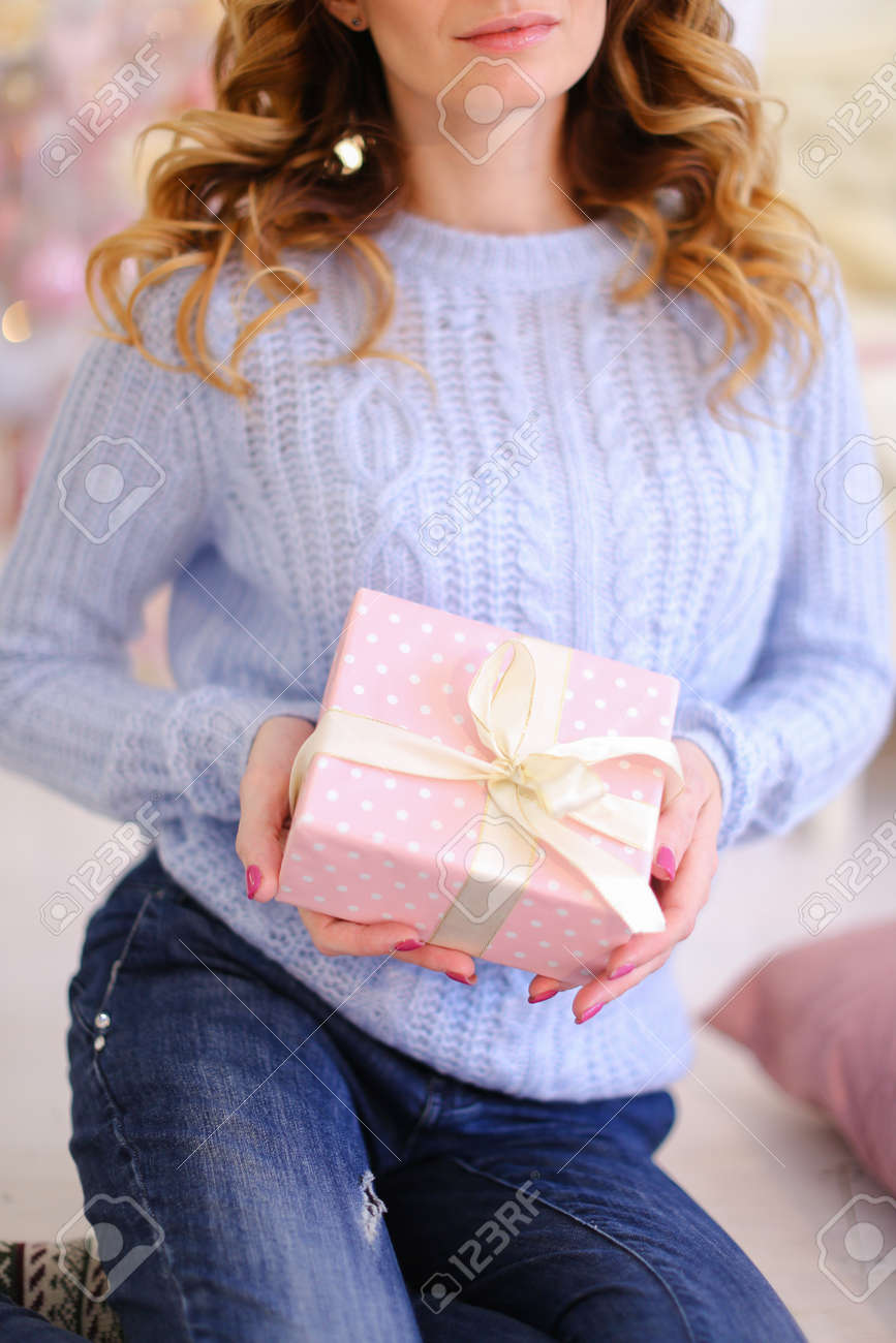 close up of christmas presentation in hands of gentle woman who