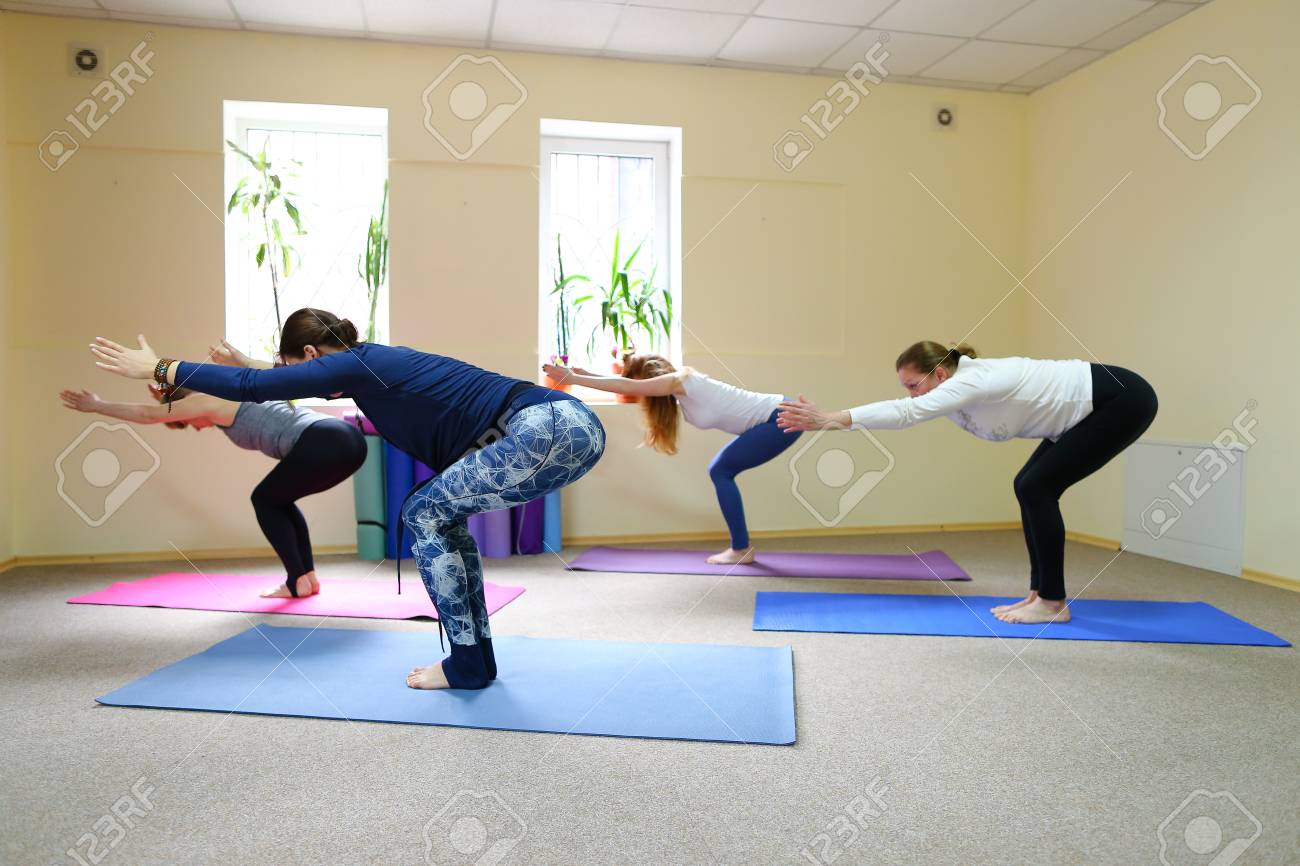 Sports woman works with muscles of arms and legs in chair pose Sports woman works with muscles of arms and legs in chair pose