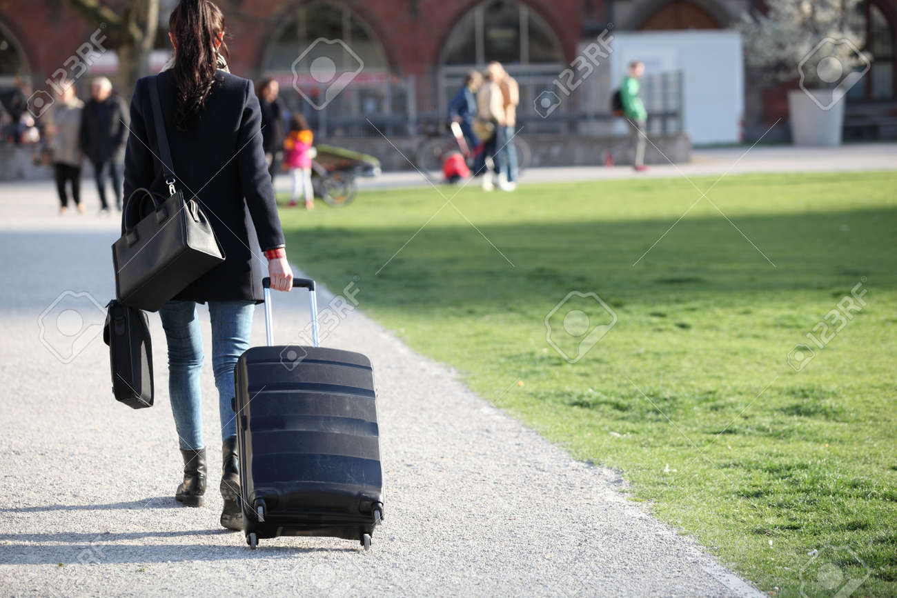 Hermosa Con Maletas De Cruzar La Calle En Una Mujer City.beautiful Grande En Una Calle Y La Celebración De Una Maleta. Mujer Joven Las Piernas Largas En Un Entorno Urbano