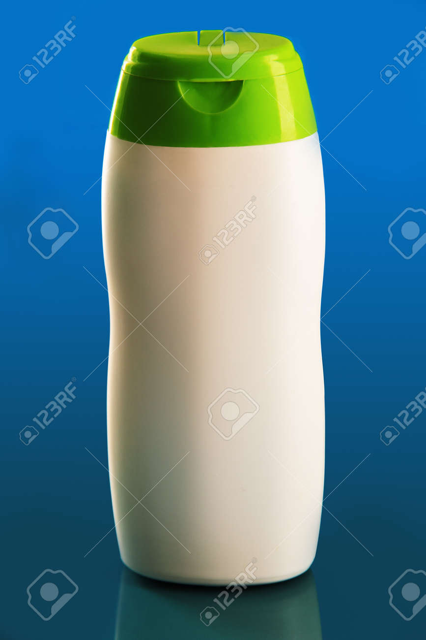 シャンプー 緑の帽子 青の背景 ガラスに映った白ボトル の写真素材 画像素材 Image