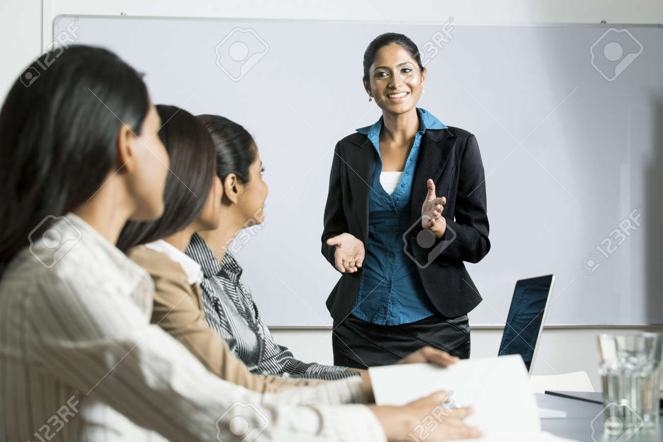 indian woman at a business meeting giving a presentation stock business meeting presentation