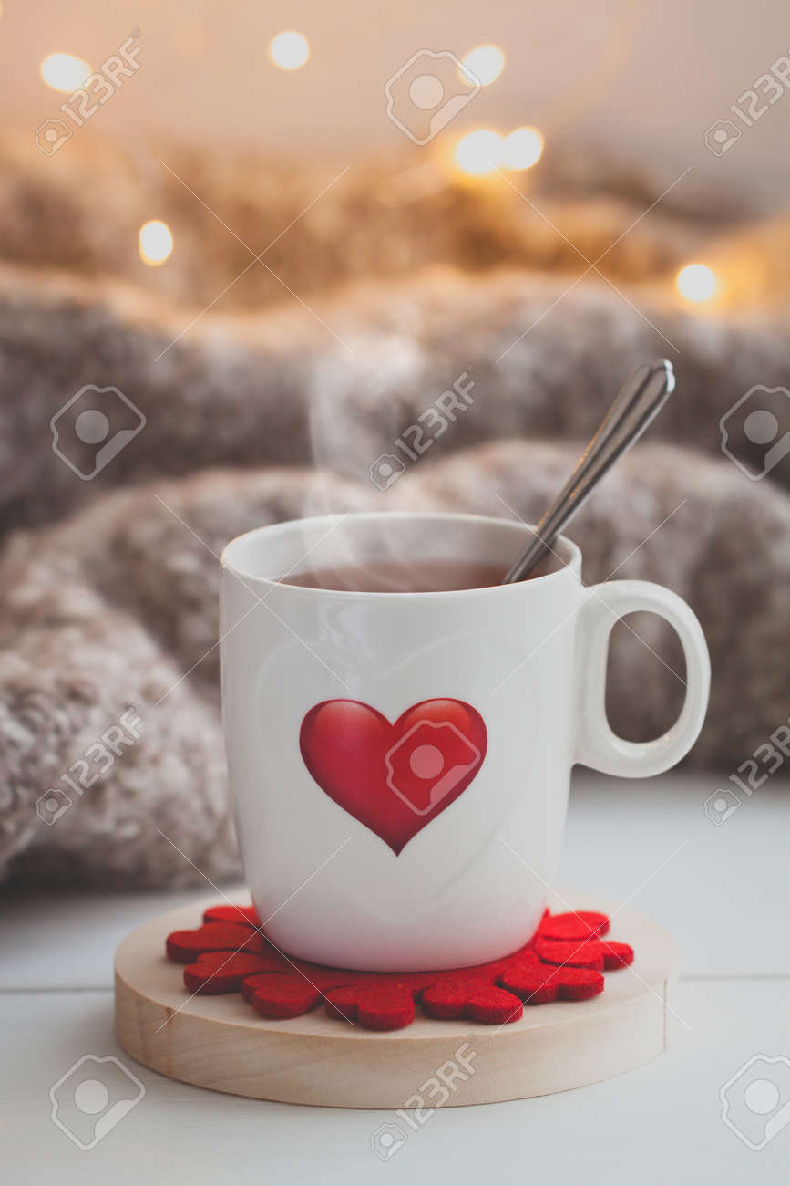 festive cup of tea with a smoke and a red heart over the knitted