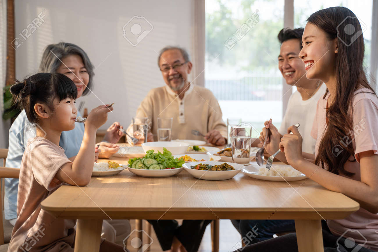 Große asiatische glückliche familie verbringt zeit beim gemeinsamen mittagessen am esstisch. kleine tochter isst gerne mit vater, mutter und großeltern. generationenübergreifende beziehung und tätigkeit im haus - 184888767 Große asiatische glückliche familie verbringt zeit beim gemeinsamen mittagessen am esstisch. kleine tochter isst gerne mit vater, mutter und großeltern. generationenübergreifende beziehung und tätigkeit im haus - 184888767