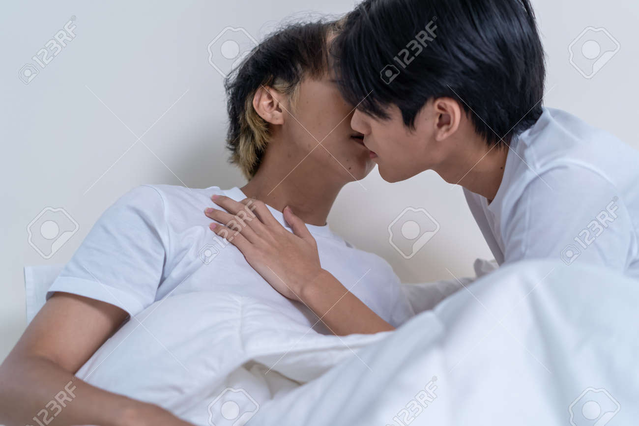 Asian Attractive Male LQBTQ Starting Foreplay And Making Love At Home.  Handsome Romantic Man Gay Couple Spending Leisure Time Together Having Sex  In Dark Night Room In House. Homosexual-LGBTQ Concept. Stock Photo,