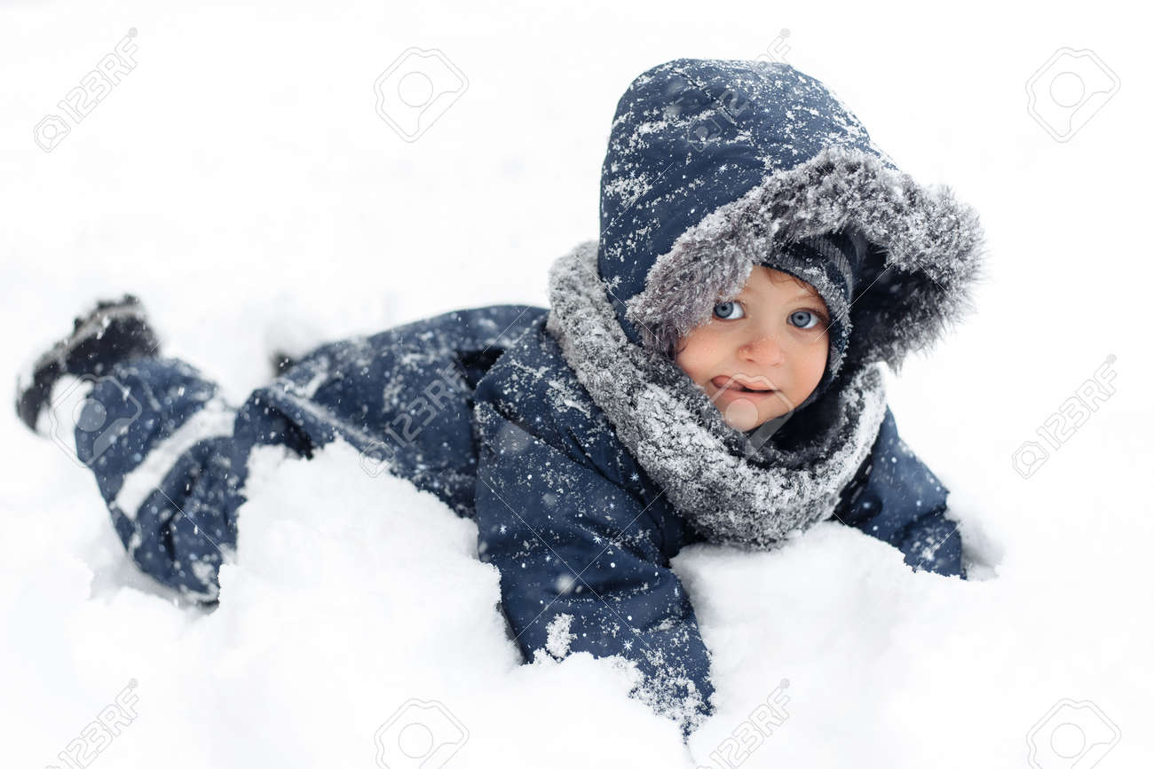 Close Up Image Of Cute Baby Boy In A Warm White Snow Suit Lying Stock Photo Picture And Royalty Free Image Image 154777220