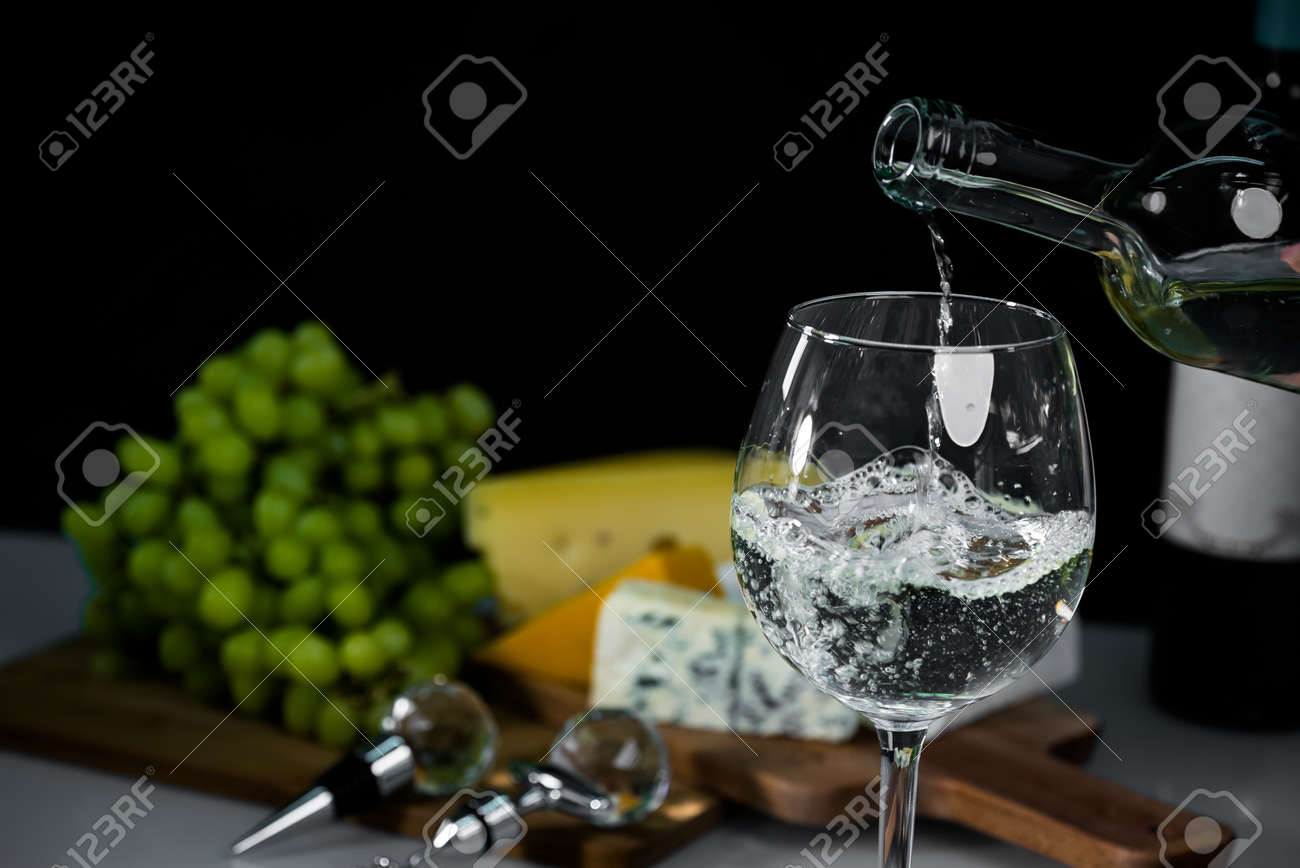 Cropped view sommelier pouring wite wine from bottle into glass - 142549802 Cropped view sommelier pouring wite wine from bottle into glass - 142549802