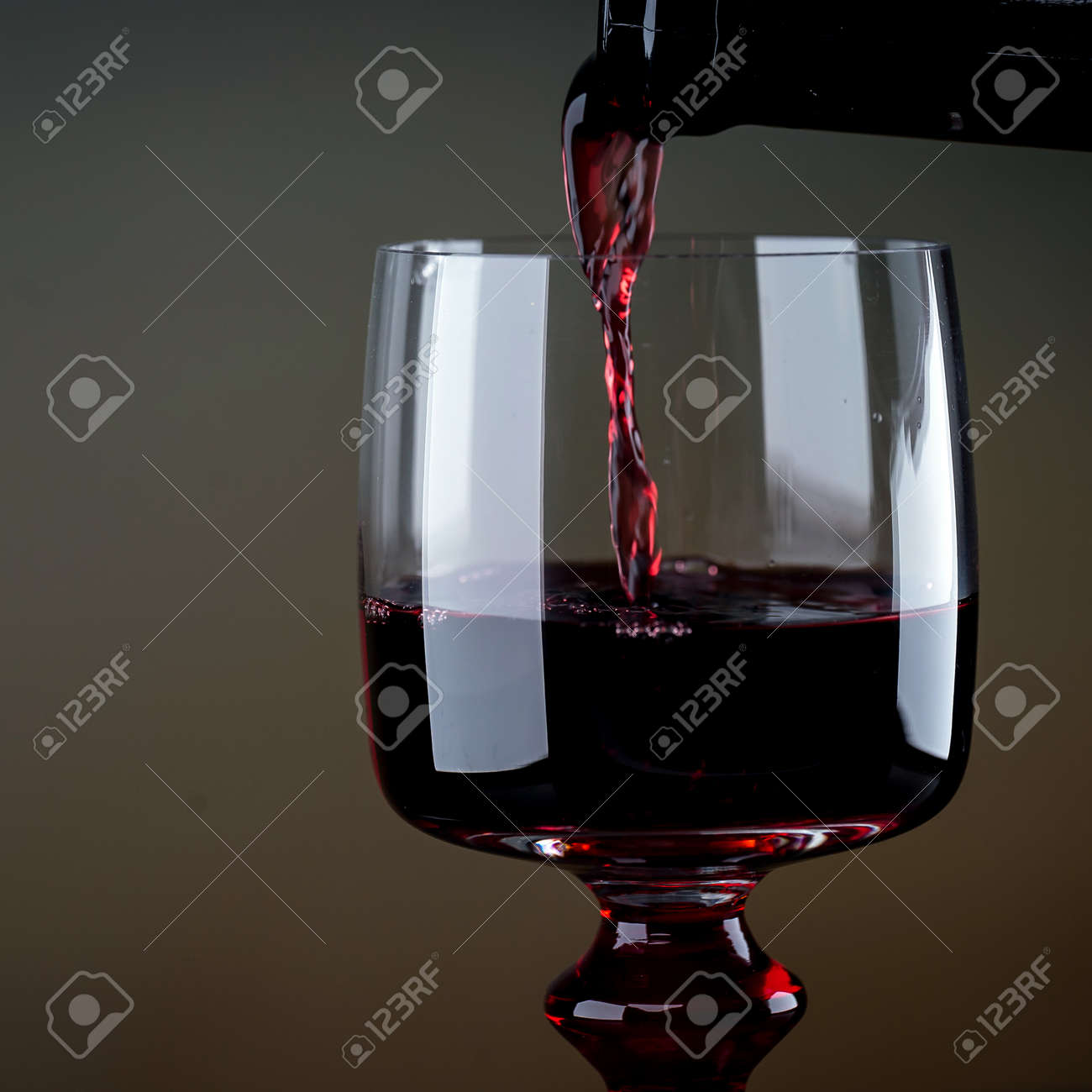 Cropped view sommelier pouring red wine from bottle into glass - 142549806 Cropped view sommelier pouring red wine from bottle into glass - 142549806