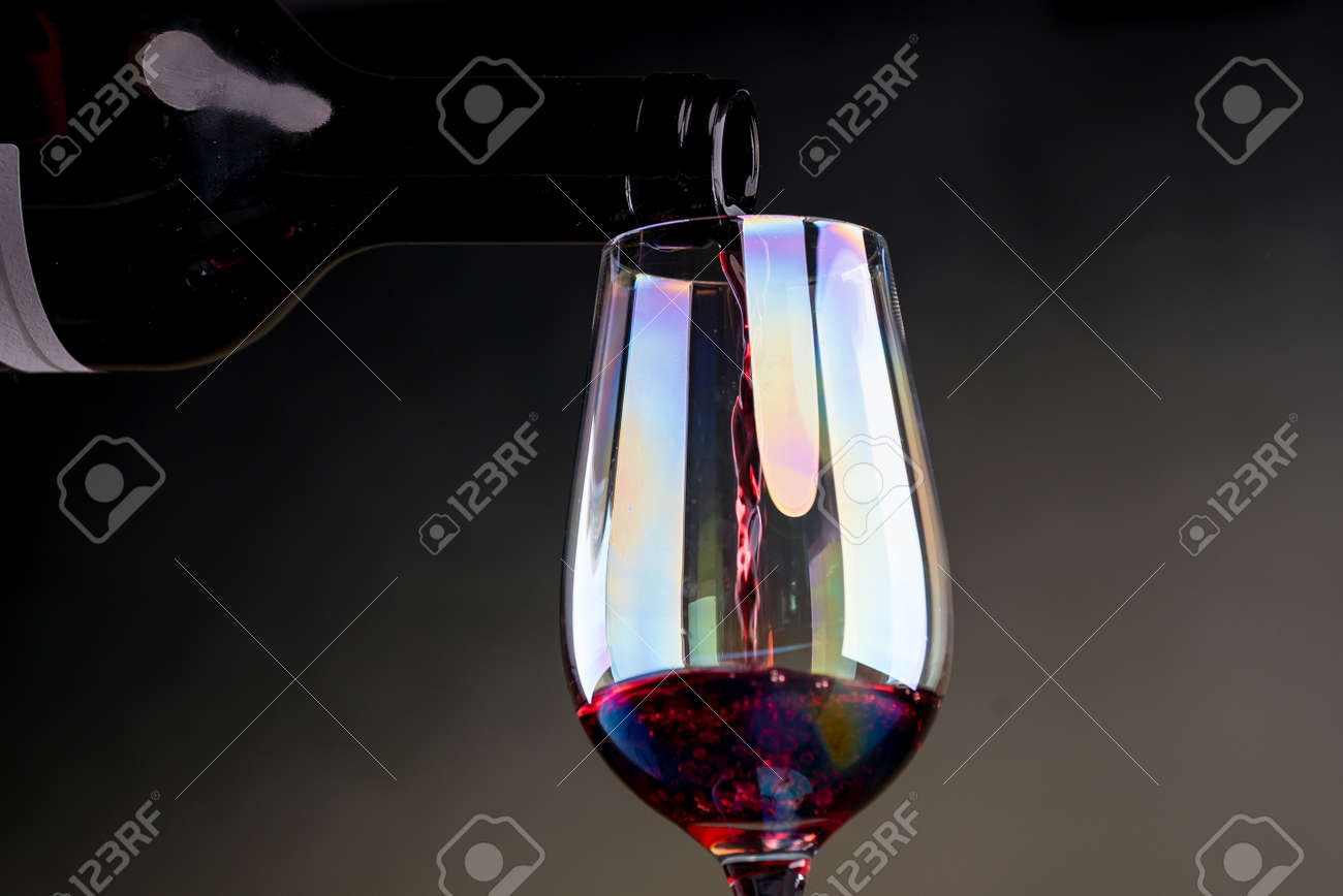 Cropped view sommelier pouring red wine from bottle into glass - 142549809 Cropped view sommelier pouring red wine from bottle into glass - 142549809