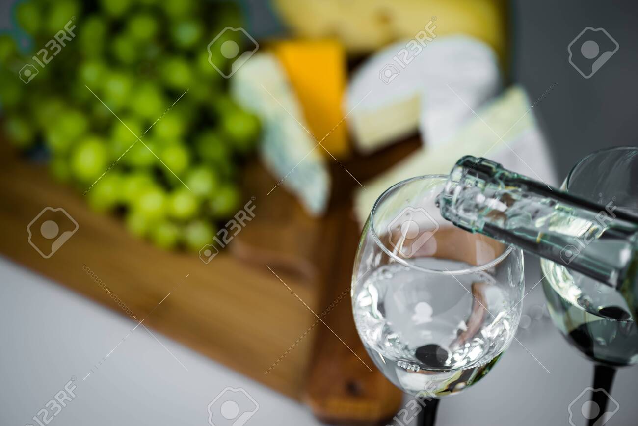 White wine being poured into a glass close-up - 142549820 White wine being poured into a glass close-up - 142549820