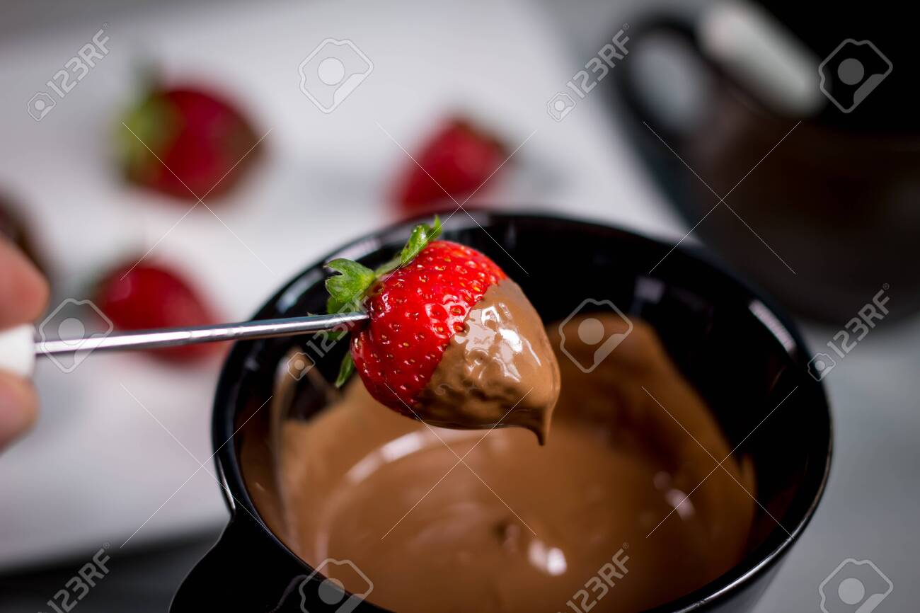 Chocolate fondue with fresh berries on wooden table - 144316027 Chocolate fondue with fresh berries on wooden table - 144316027
