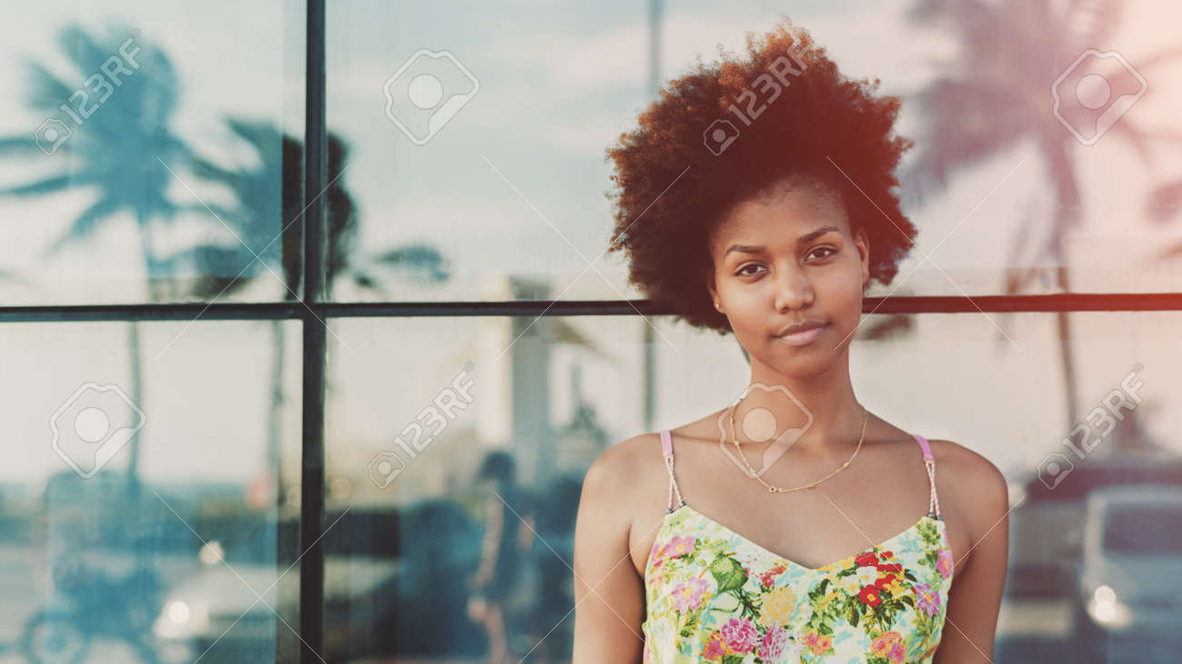 teen brazilian Portrait Of Young Beautiful Cute Mixed Brazilian Teen Girl With Curly Hair Standing In Front Of Tiled Glass Wall With Reflections Of Palms And Cars, Sunny Summer Day, Rio De Janeiro, Brazil