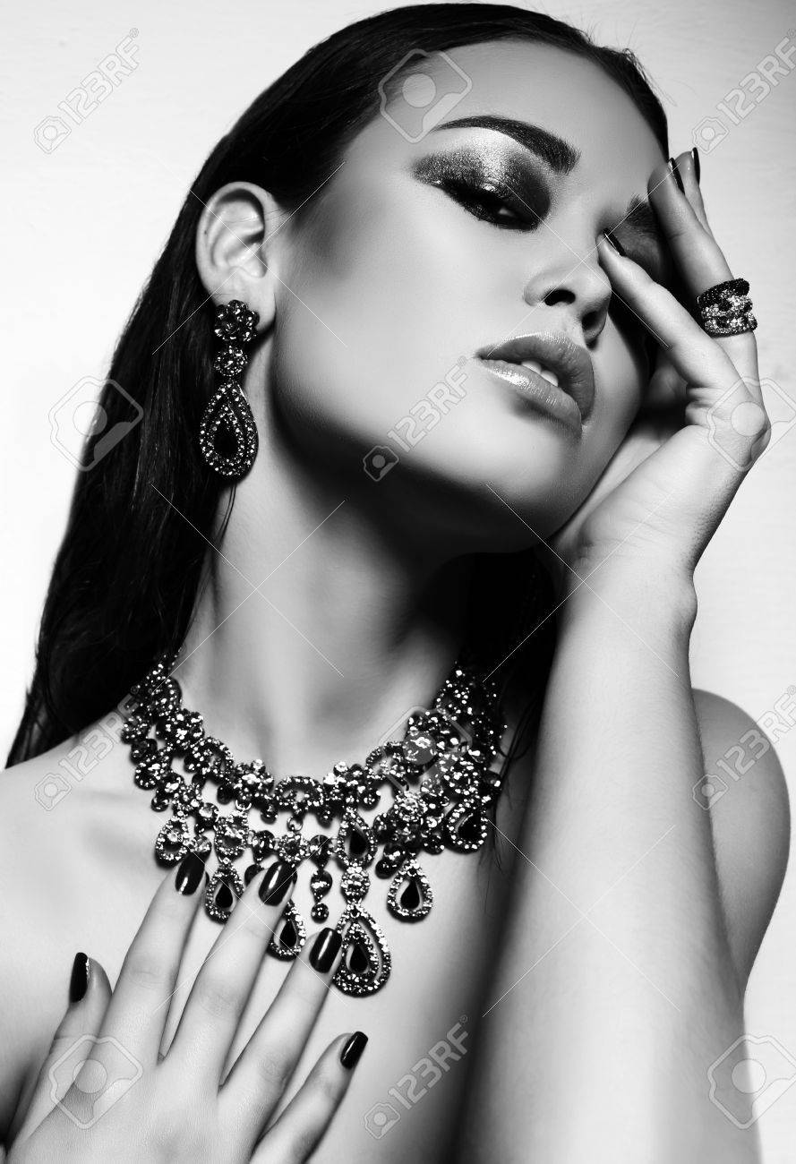 Fashion studio black and white photo of gorgeous sexy woman with dark hair and bright makeup