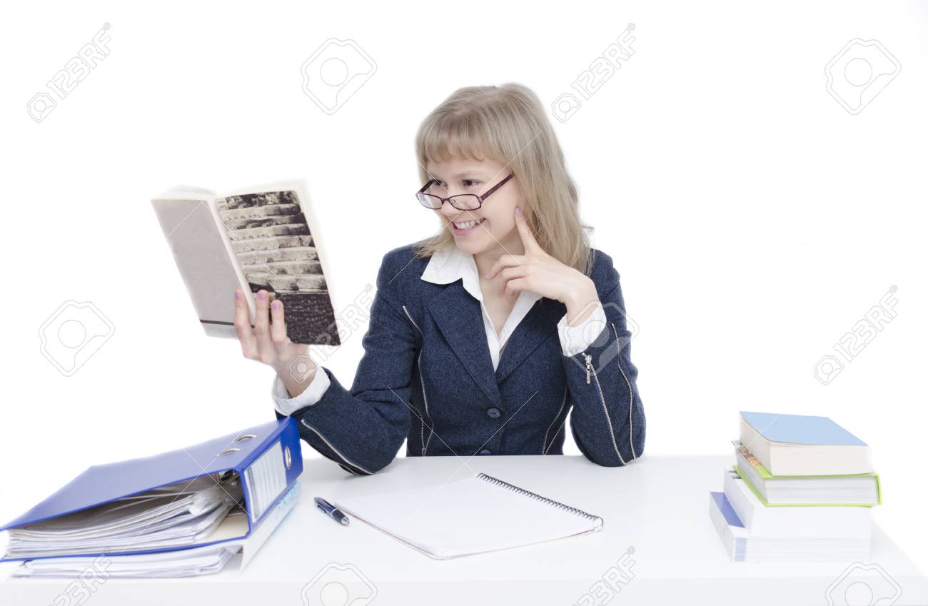 A young woman is sitting at the desk and is studying - 24703208 A young woman is sitting at the desk and is studying - 24703208