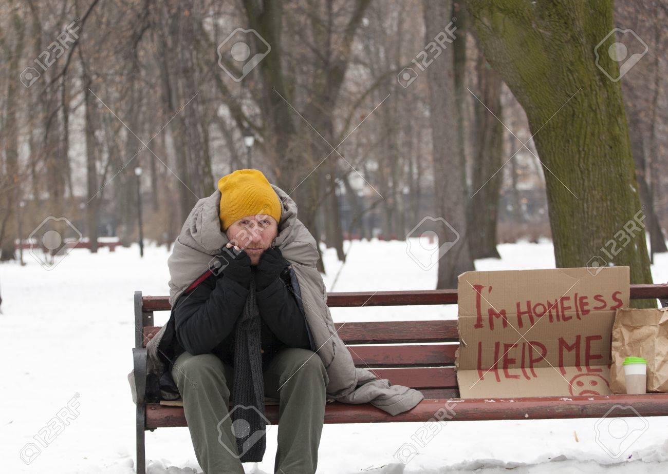 冬都市公園における段ボールと大人のホームレスの男性がベンチに座ってください の写真素材 画像素材 Image