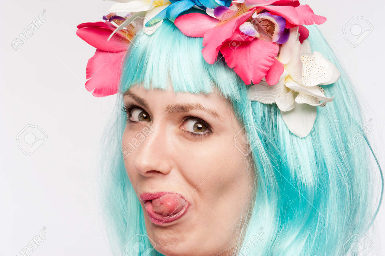 Girl with headdress and blue wig sticking her tongue out in studio on white background. - 42315170 Girl with headdress and blue wig sticking her tongue out in studio on white background. - 42315170