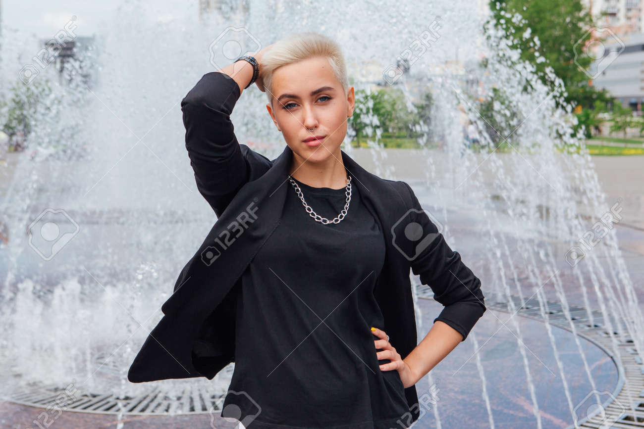 Jeune Femme Daffaires Élégante Avec Des Cheveux Courts Et Un Piercing Au  Nez. Une Fille Confiante Ressemble À Une Lesbienne Debout Près Dune  Fontaine Banque DImages et Photos Libres De Droits. Image