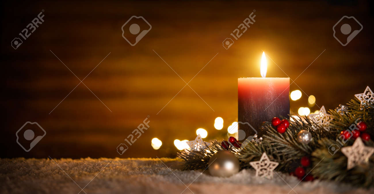 Burning candle and Christmas decoration over snow and wooden background, elegant low-key shot with festive mood - 65438162 Burning candle and Christmas decoration over snow and wooden background, elegant low-key shot with festive mood - 65438162