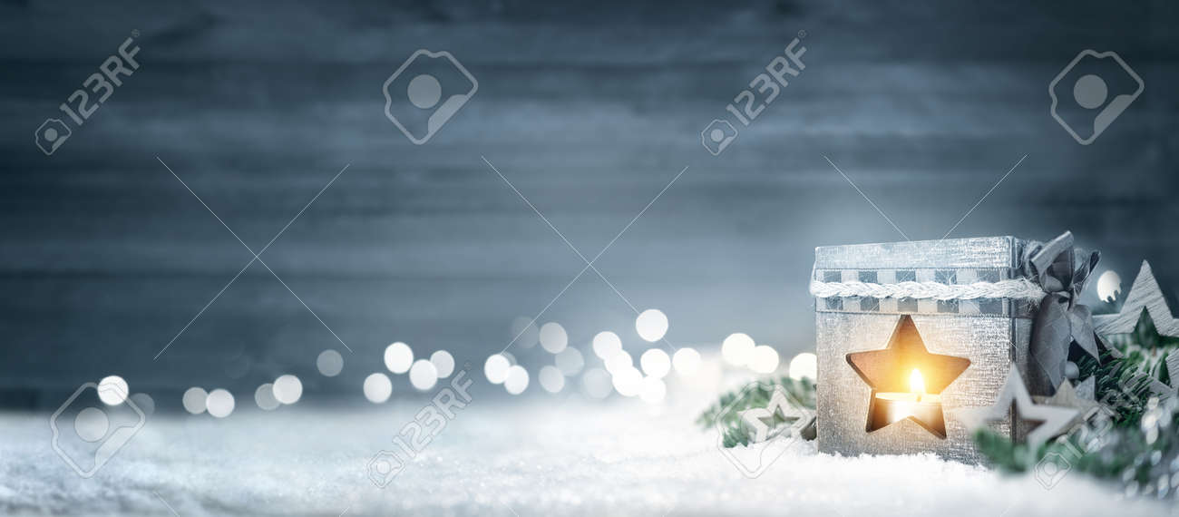 Christmas background in cool winter colors with a shining lantern, wood board, fir branches, ornaments and out of focus lights - 88755582 Christmas background in cool winter colors with a shining lantern, wood board, fir branches, ornaments and out of focus lights - 88755582