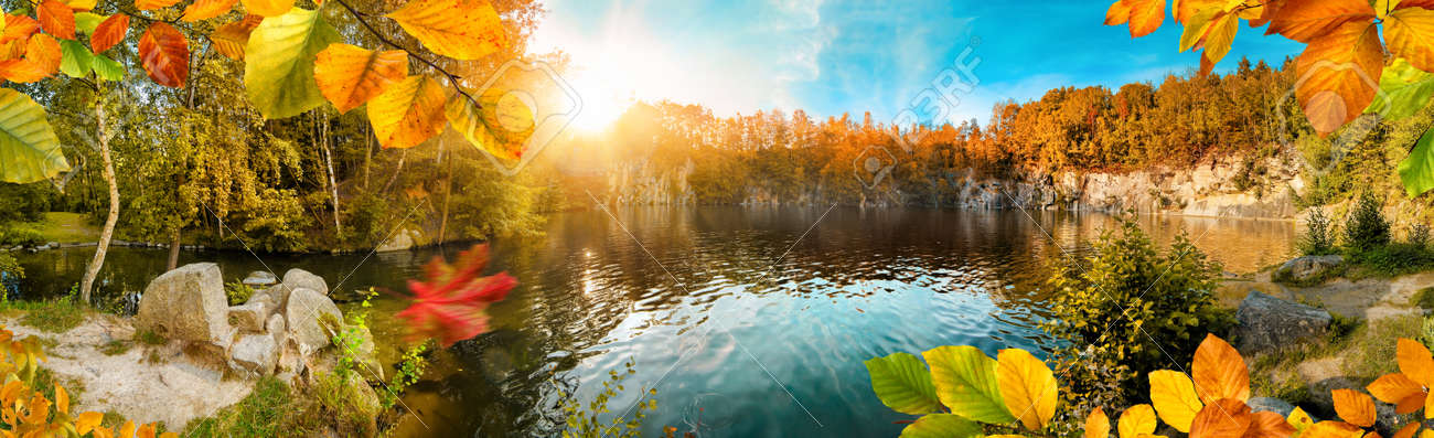 Magnificent autumn landscape panorama with colorful foliage framing a beautiful blue lake, with sun and blue sky - 156640003 Magnificent autumn landscape panorama with colorful foliage framing a beautiful blue lake, with sun and blue sky - 156640003