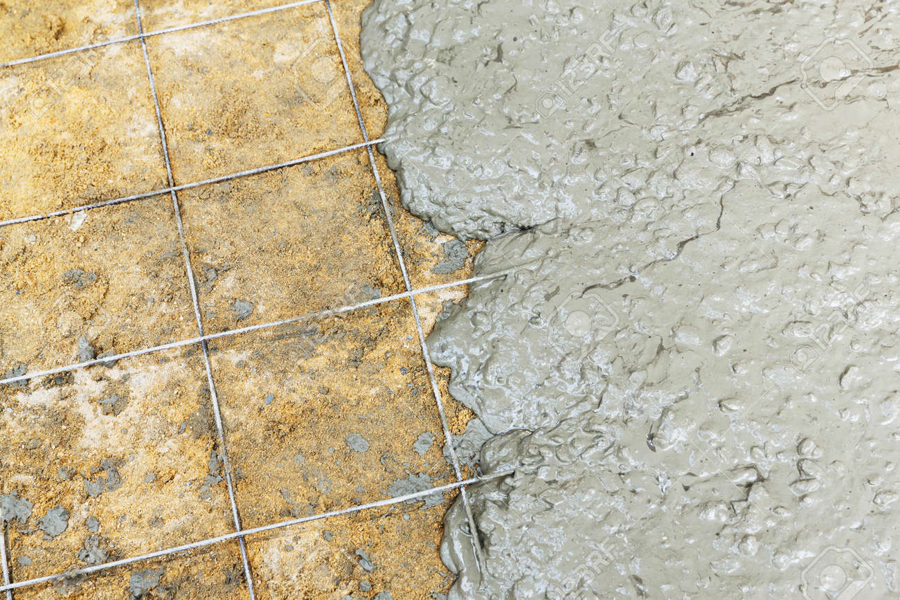 Close Up Wire Mesh And Wet Cement In Concrete Floor Pouring
