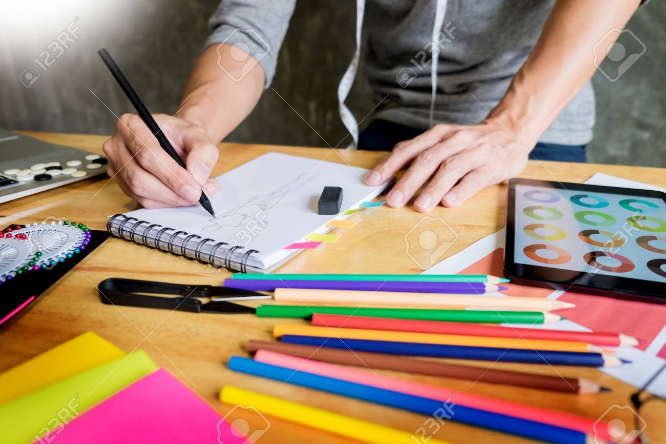 men working as fashion designer drawing sketches for clothes..