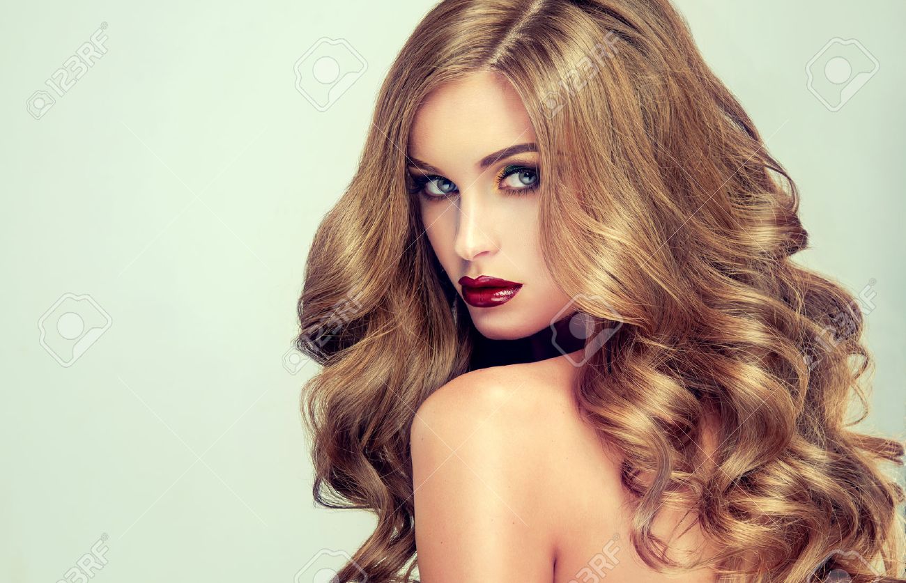 Peinados dulados peinados para cabello largo ondulado con la hermosa chica con el pelo largo y ondulado modelo rubio con el peinado rizado y