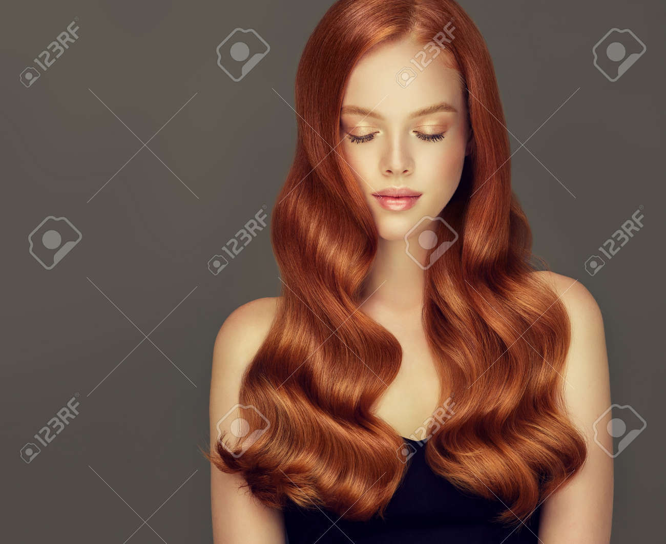 Young, red haired beautiful model with long, curly, well groomed hair. Irish beauty. Excellent hair waves. Hairdressing art and hair care. - 114695652 Young, red haired beautiful model with long, curly, well groomed hair. Irish beauty. Excellent hair waves. Hairdressing art and hair care. - 114695652