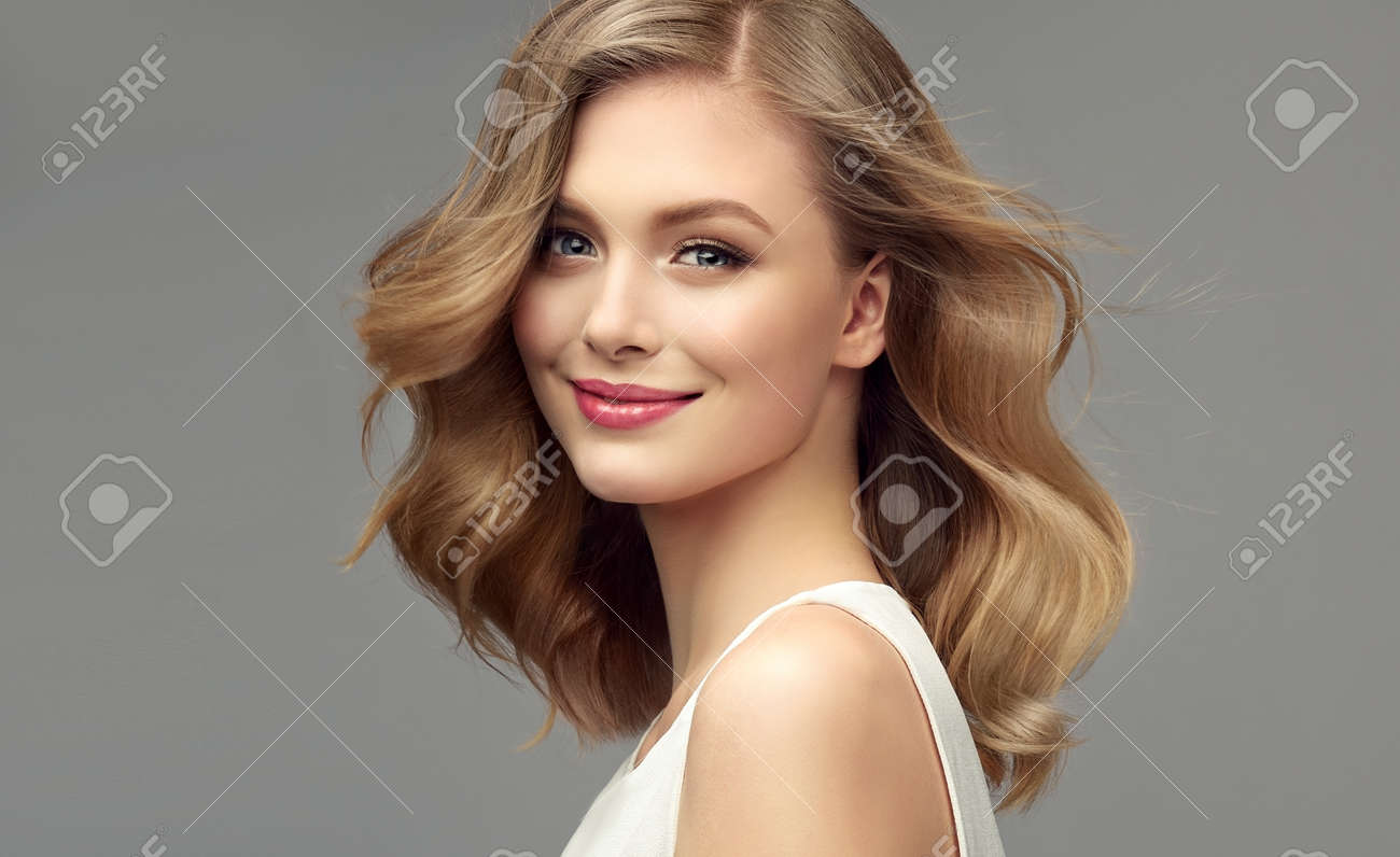 Model with dark blonde hair. Frizzy, elegant hairstyle is surrounding lovely face of tenderly smiling young woman. Hair care and hairdressing art. - 133213399 Model with dark blonde hair. Frizzy, elegant hairstyle is surrounding lovely face of tenderly smiling young woman. Hair care and hairdressing art. - 133213399