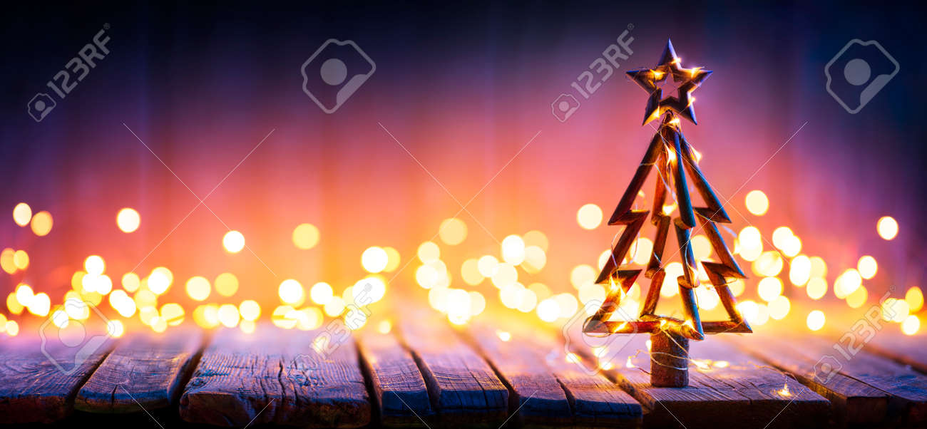 Christmas Light And Wooden Tree On Table With Defocused Rustic Background - 159435984 Christmas Light And Wooden Tree On Table With Defocused Rustic Background - 159435984