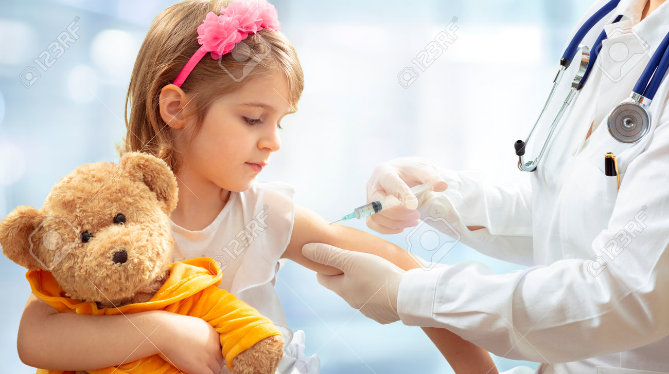 Vaccination Concept - Female Doctor Vaccinating Cute Little Girl On Blue Background - 162813988 Vaccination Concept - Female Doctor Vaccinating Cute Little Girl On Blue Background - 162813988