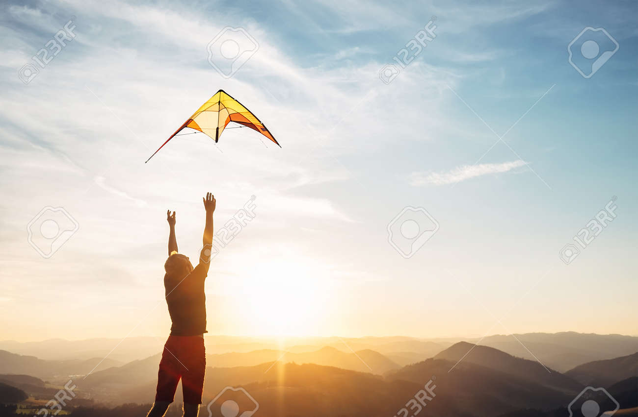 Man start to fly a kite in the sky - 107564882 Man start to fly a kite in the sky - 107564882