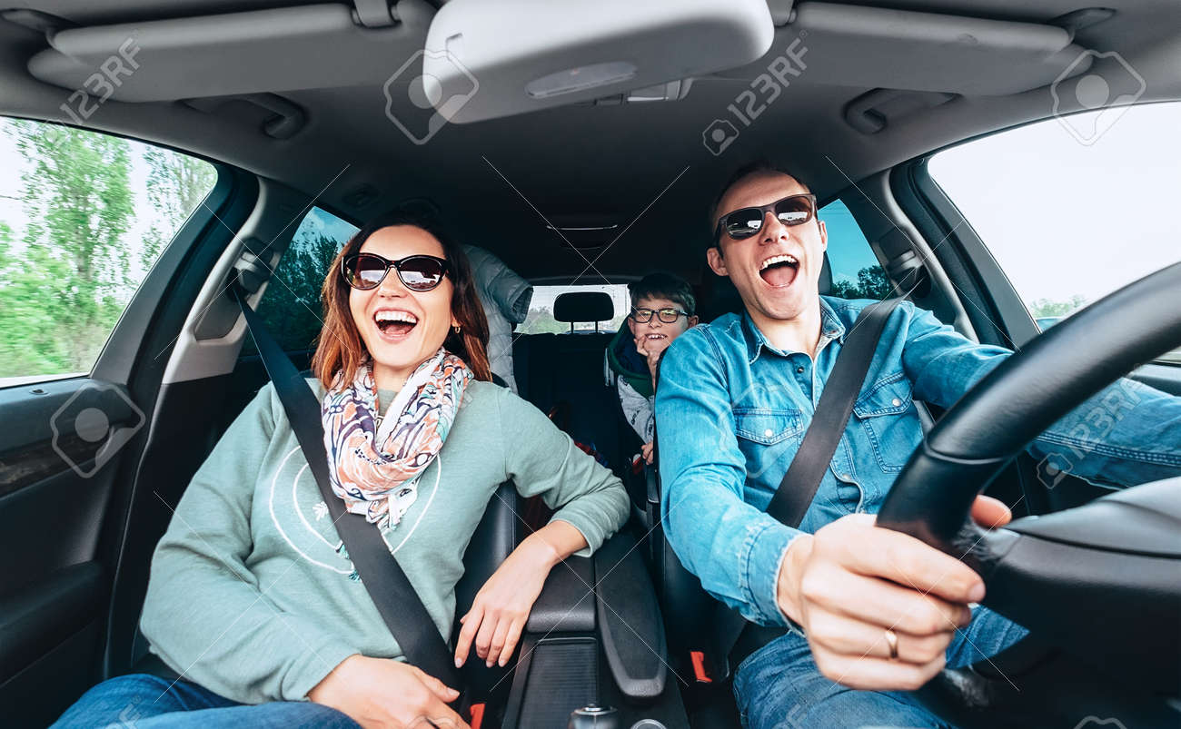 Cheerful young traditional family has a long auto journey and singing aloud the favorite song together. Safety riding car concept wide angle inside car view image. - 115454201 Cheerful young traditional family has a long auto journey and singing aloud the favorite song together. Safety riding car concept wide angle inside car view image. - 115454201