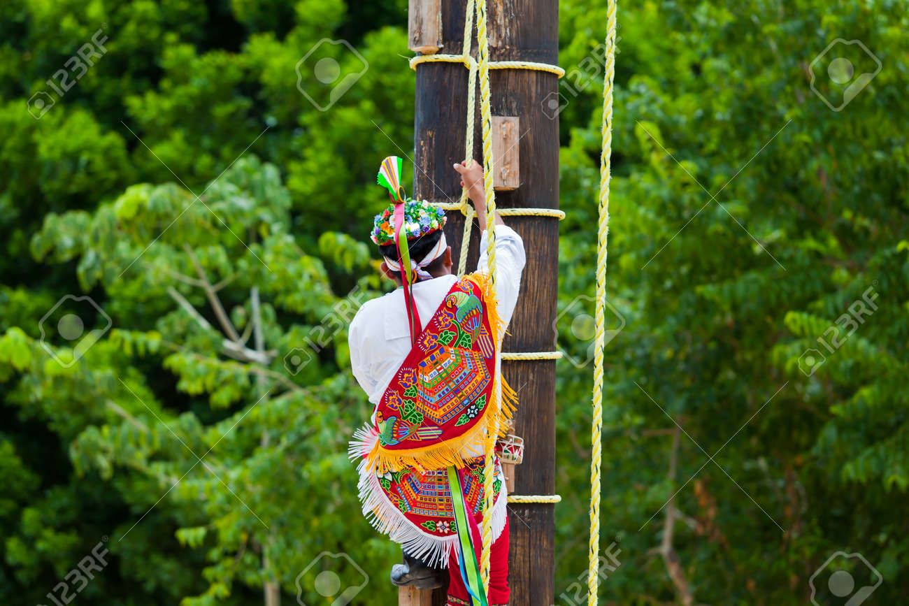 traditional mayan flyer man climbing a wooden pole in the dance the dance of the flyers