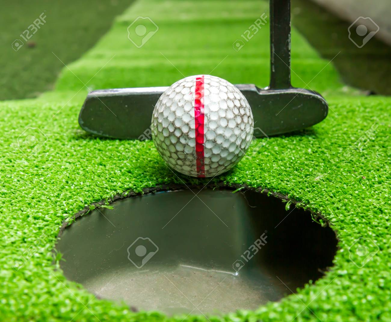 クローズ アップ 古いゴルフ ボールとパターの練習のための人工の草の上 の写真素材 画像素材 Image