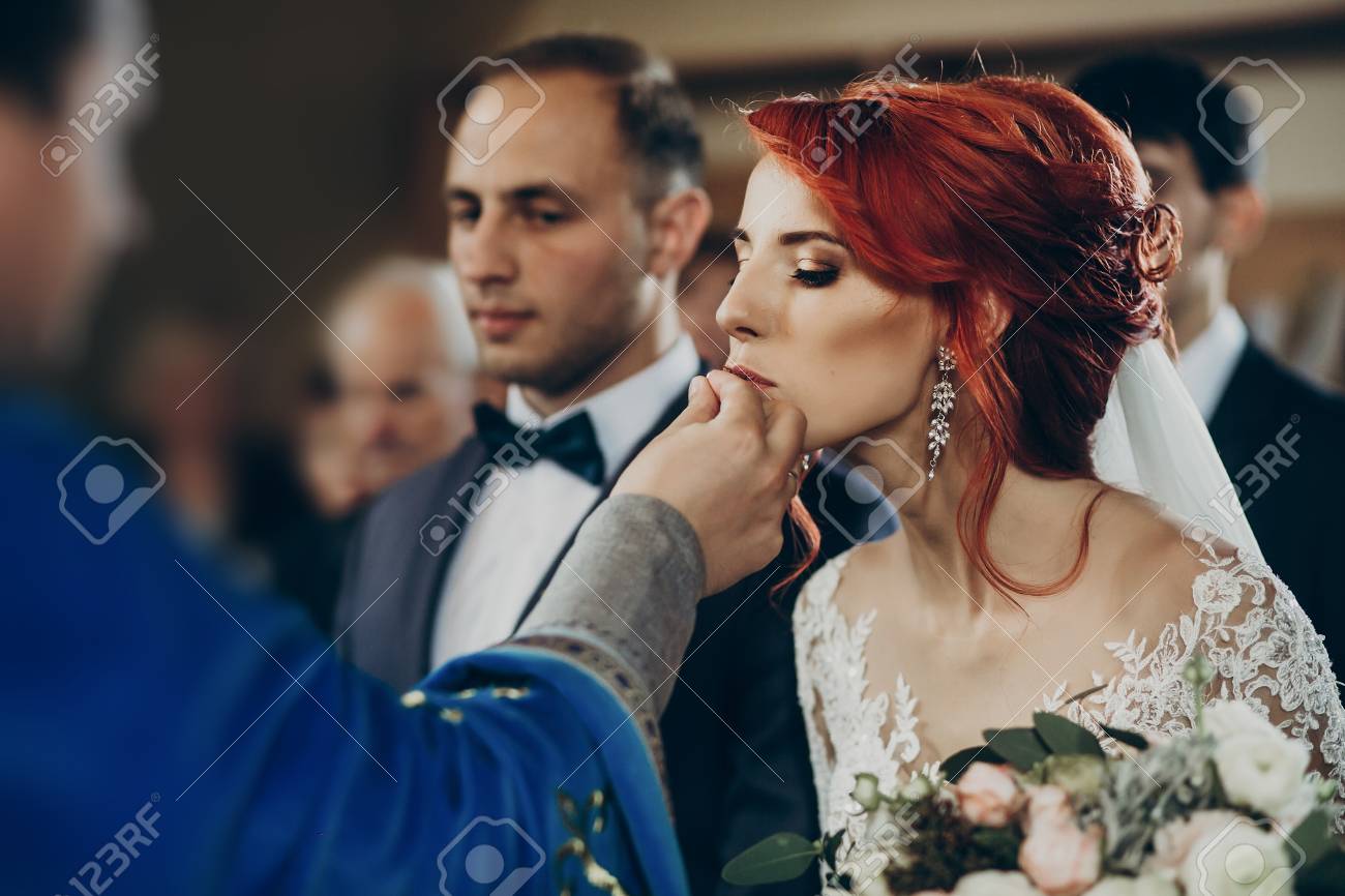 Pareja De Poniendo Anillos De Boda En El Matrimonio La Iglesia. Elegantes Novios E Intercambiando Anillos. Momento Emocional, Espacio Para El Texto. Concepto De Religion Fotos, Retratos, Imágenes Y