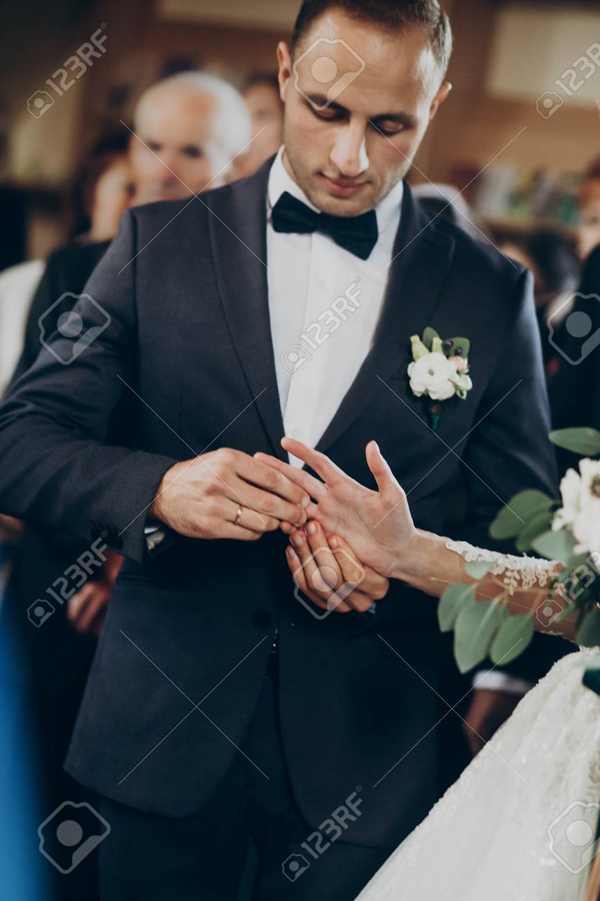 Pareja De Poniendo Anillos De Boda En El Matrimonio La Iglesia. Elegantes Novios E Intercambiando Anillos. Momento Emocional, Espacio Para El Texto. Concepto De Religion Fotos, Retratos, Imágenes Y