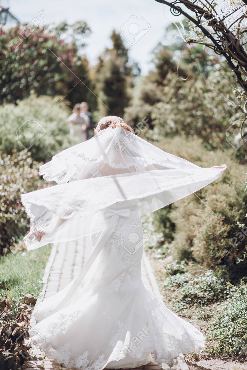 美しい豪華な花嫁ベール ポーズと 日当たりの良い春パークで楽しんで 緑の庭に立って幸せな女 幸せな結婚の瞬間 駆け落ちのコンセプト の写真素材 画像素材 Image