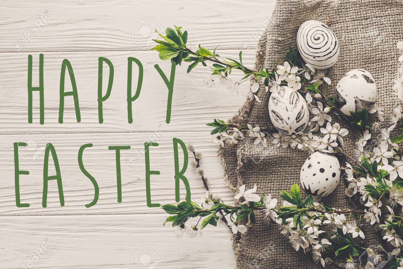 Happy Easter Text Flat Lay With Flowers And Stylish Eggs On Rustic
