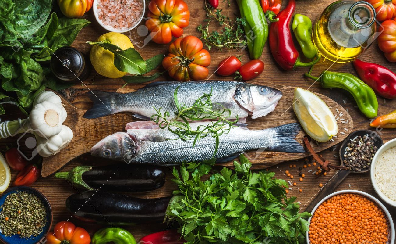 Raw uncooked seabass fish with vegetables, grains, herbs and spices on chopping board over rustic wooden background, top view - 58854348 Raw uncooked seabass fish with vegetables, grains, herbs and spices on chopping board over rustic wooden background, top view - 58854348