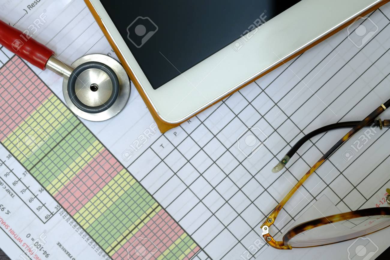 a red stethoscope a patient vital sign sheet a tablet and stock