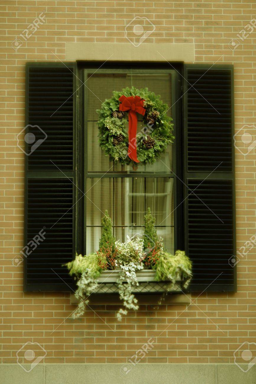 Brick Apartment Building Window christmas wreath hanging in window of brick apartment building Brick Apartment Building Window christmas wreath hanging in window of brick apartment building