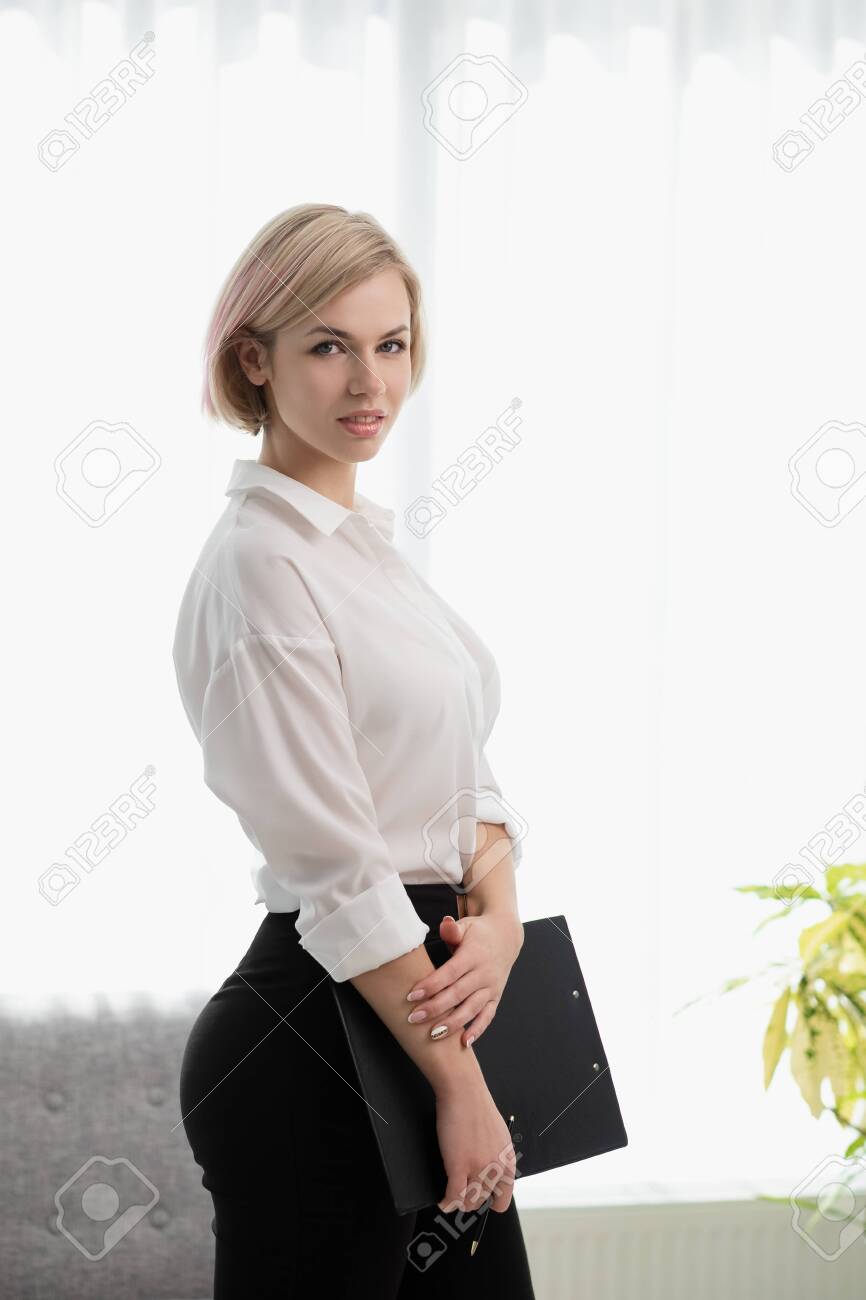 Young Beautiful Blonde Girl With Short Hair In A White Shirt