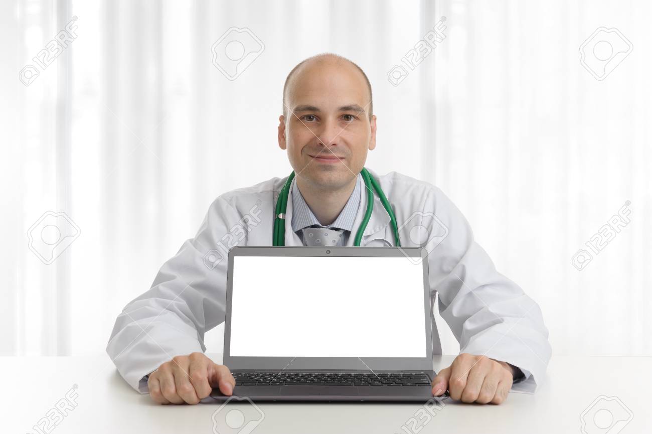 Handsome Doktor Sitting At A Desk With Laptop Computer Stock Photo Picture And Royalty Free Image Image