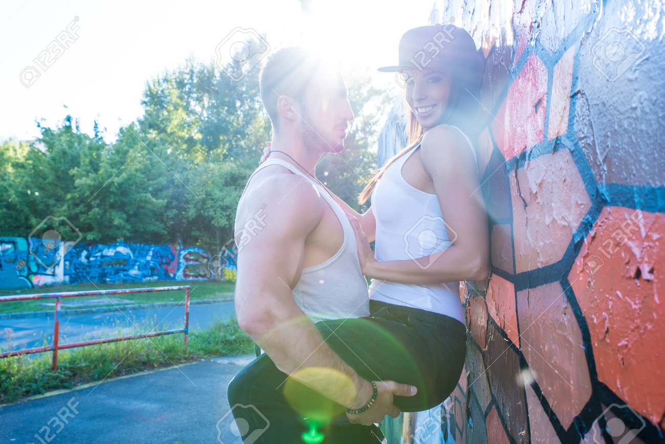 Un Varon Joven Que Sostiene La Chica De La Pared Durante La Puesta