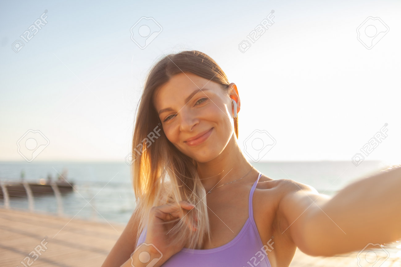 Selfie portrait of a young blonde woman dressed in sportswear on the beach at sunrise - 166588840 Selfie portrait of a young blonde woman dressed in sportswear on the beach at sunrise - 166588840
