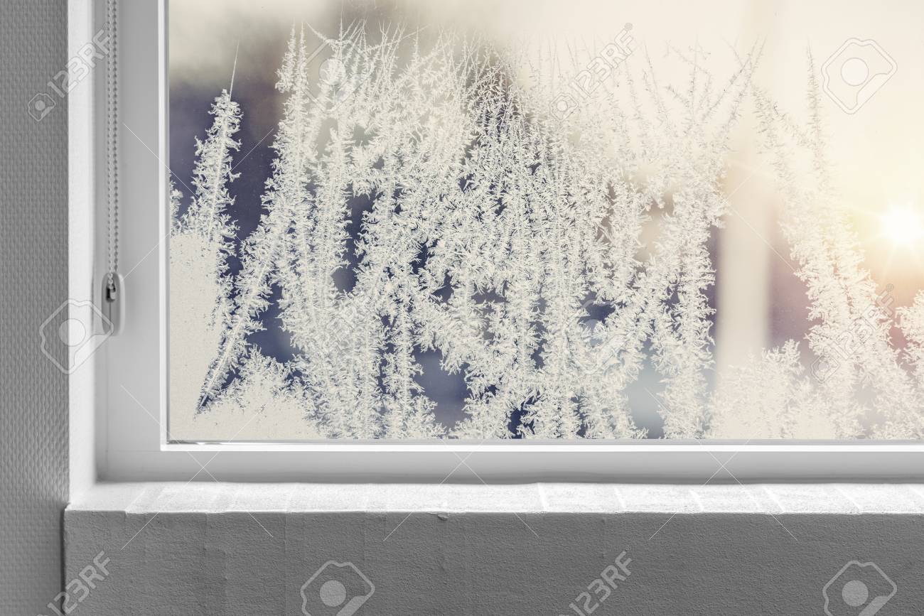 Frosty window seen from the inside with a white windowsill in the winter - 118141095 Frosty window seen from the inside with a white windowsill in the winter - 118141095