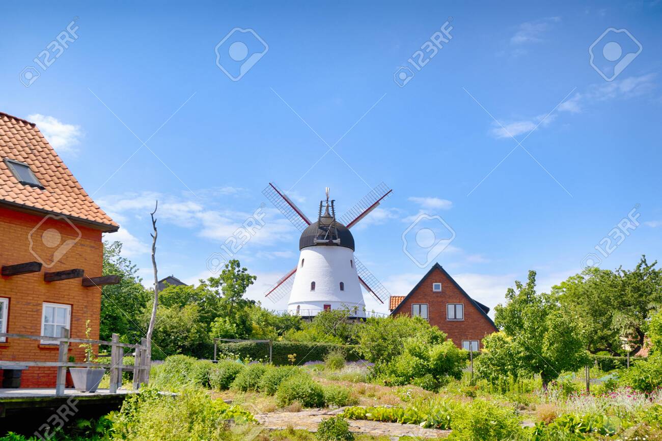 Old mill in a green garden in the summertime under a blue sky - 129713889 Old mill in a green garden in the summertime under a blue sky - 129713889